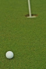 Golf ball in front of the hole