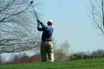 Male golfer teeing off on a ball