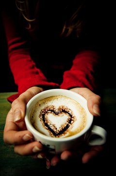 Hands Holding Coffee with Cocoa Heart in the Cup