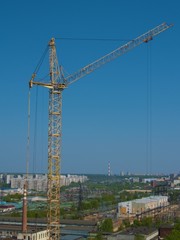 Fototapeta na wymiar City landscape with yellow crane erecting