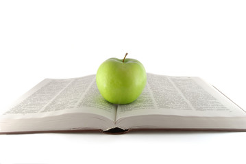 Open book with green apple