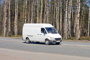 blank van drives near forest