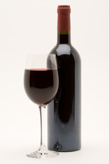 red wine bottle with filled wineglass in front