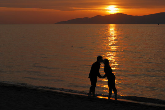 Young couple kissing on Jericho beach at sunset