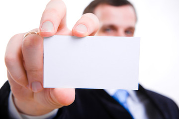 A studio shot of a businessman holding out a blank business card