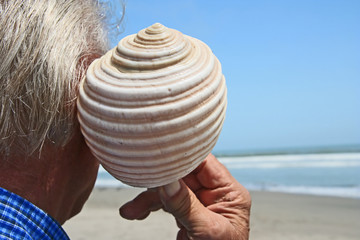 Senior enjoying sound of a shell