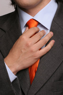 Detail of a man, fixing his tie