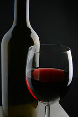 Wine bottle and glass over black background