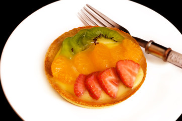 Fruit and Custard Tartlet on a white plate.