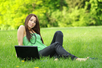 Portrait of sexy woman on green background using laptop