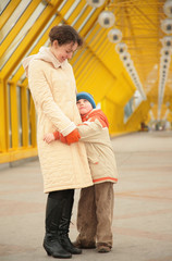 Fototapeta premium son embraces mother on footbridge