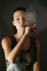 Fototapeta premium Sensual girl in camouflage top smoking