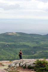 Solitary hiker standing on a granite mountaintop