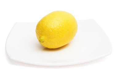 Yellow lemon on white ceramic plate
