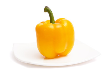 Yellow paprika on white ceramic plate