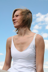 Fototapeta na wymiar junge Frau schaut in die Ferne, die Haare vom Wind verweht