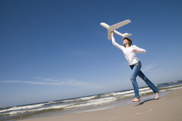 Obraz premium Teenager with plane on the beach