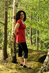 Happy young woman in birch wood 