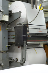 Large rolls of paper on a printing press