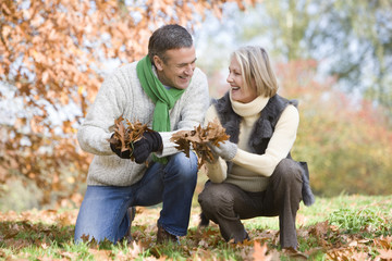 Senior couple collecting autumn leaves