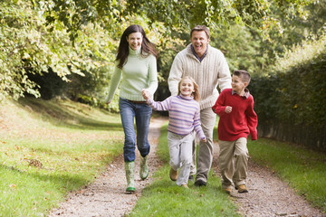 Family running along woodland track