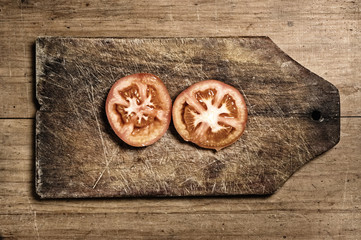 Tomatoes on old wooden table, studio shot.