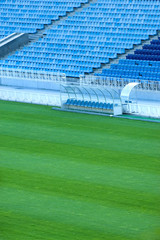 Fototapeta premium Football stadium seats and grass field of the stadium in Kiev