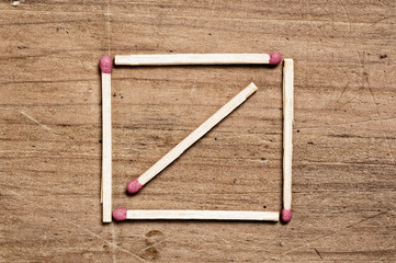 Matches on wooden surface forming a square shape.
