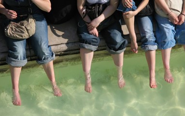 Femmes se rafraîchissant les pieds dans l'eau d'un bassin