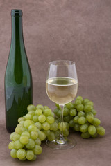 Weisser Wein mit Flasche, Gläser und Trauben