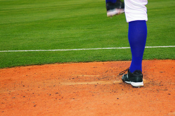 Obraz premium Baseball pitcher on the mound, in throwing motion