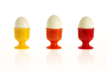 three eggs in colorful egg cups