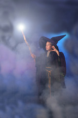 Young child in a wizard costume casting a spell.