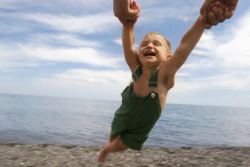 Fototapeta na wymiar flying child on beach background