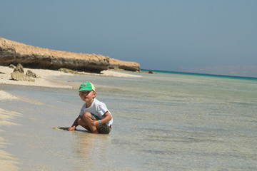 The little boy plays on a beach