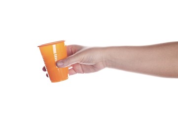 Orange plastic cup in female hand isolated on white.