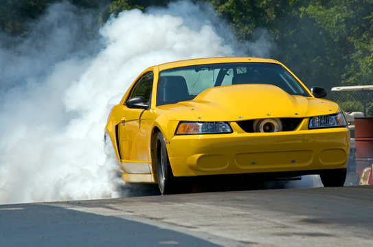 Smoke from the tires of a yellow racer