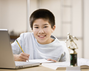 Portrait of a young boy doing homework