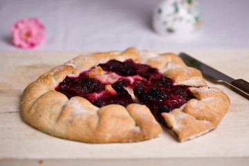 Blackberry tart on wooden board and knife