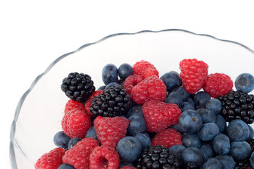 fresh berries in glass plate on white background