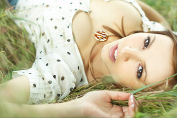 Obraz na płótnie Canvas beautiful girl lying down of grass