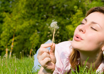 happy girl blowing on the dandelion