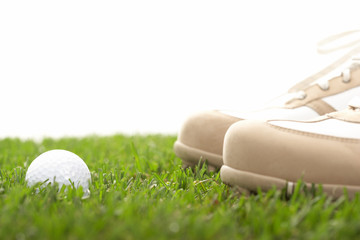 high key shot of golfball with golfshoes
