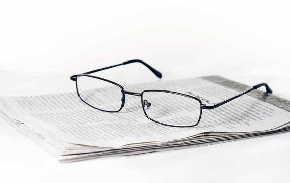 Glasses on folded newspaper