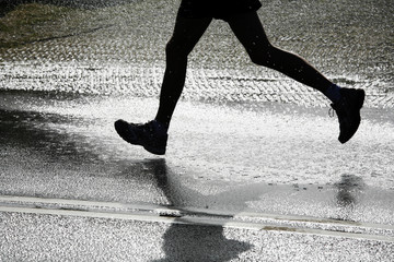 Marathon runner passing a jet of water for cooling down
