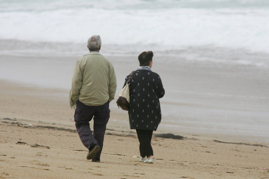 couple de retraités qui marchent sur la plage