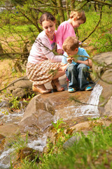 mother with children look on little waterfall