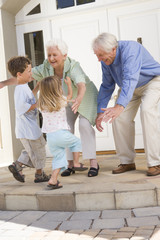 Grandparents welcoming grandchildren - obrazy, fototapety, plakaty