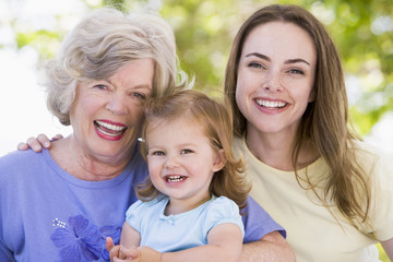 Grandmother with adult daughter and grandchild in park