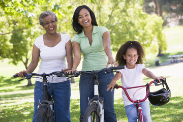 Grandmother with adult daughter and grandchild riding bikes